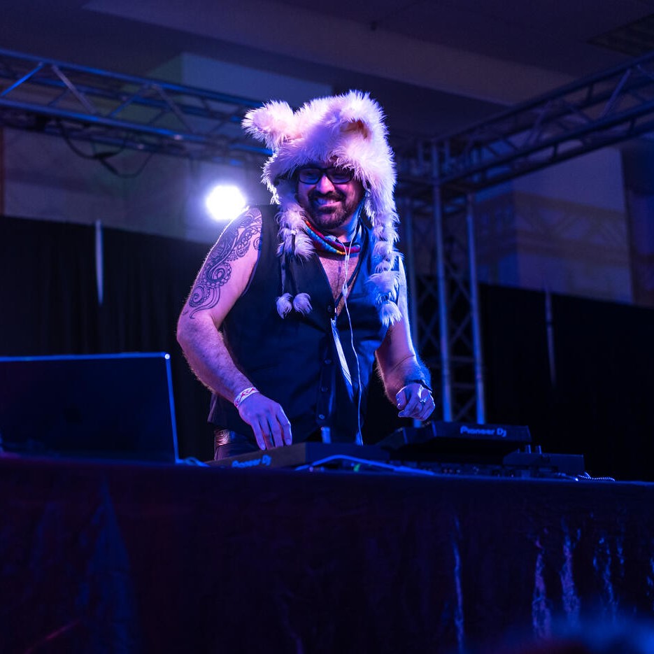 Color picture of diem mixing, wearing a furry hat with wolf style ears and and sleeveless vest.