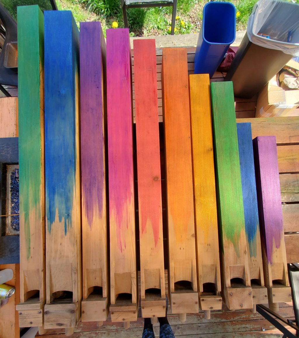 2024 Interactive Experiences: Old organ pipes that have been painted in rainbow colors.