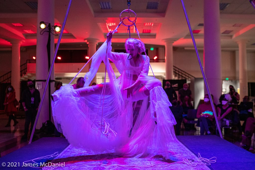 2024 Performance Curators: Shay Tiziano mid self-suspension wearing a voluminous, gauzy sheer robe. Picture from 2022 SEAF.